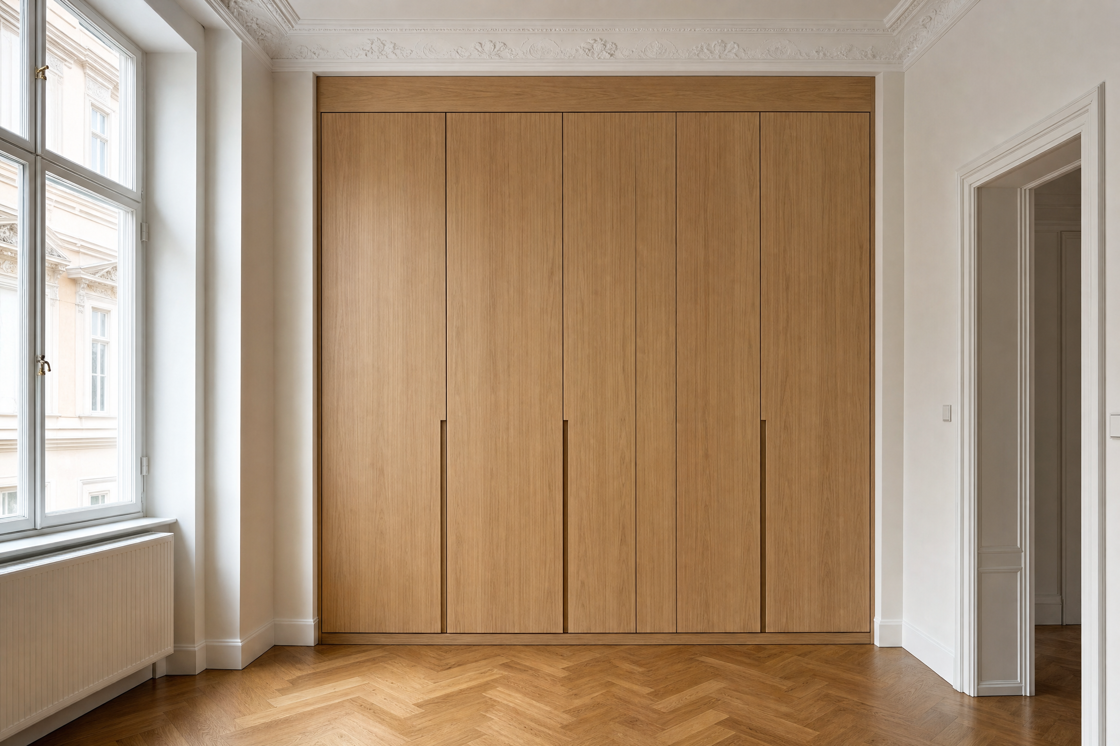 Maßgefertigter raumhoher Einbauschrank aus Eichenfurnier in einer Altbau-Nische mit Fischgrätparkett